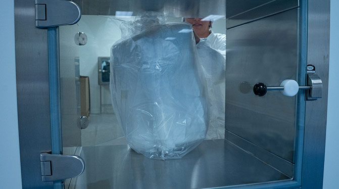 Employé AQF dans une salle propre ISO 8 veillant à ce que les produits restent à des niveaux de contamination contrôlés